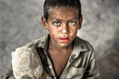 꾀죄죄한 모습으로 화면을 쳐다보는 남자아이